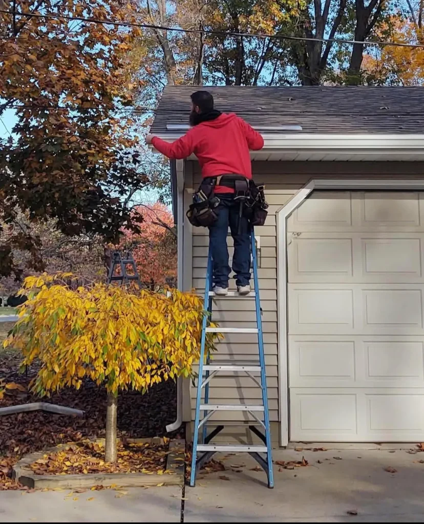 Gean Roofing team member installing new gutter system on a residential home